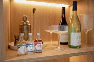 cuatro botellas de vino y copas en un estante en Sunnymead Hotel, en Aireys Inlet