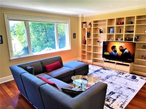 een woonkamer met een bank en een tv bij iResidence in Toronto - LUX 3 Bedroom Vacation Home in Toronto