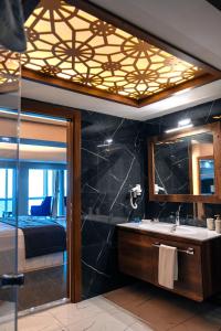 een badkamer met een wastafel, een bed en een spiegel bij Mira Hotel Boutique in Izmir