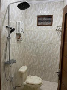 uma casa de banho com um chuveiro e um WC. em AW Lor House - Yogyakarta em Sleman