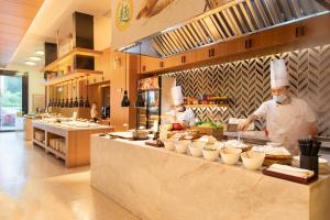 廣州的住宿－廣州天河公園萬楓酒店，两名厨师站在厨房准备食物