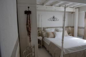a bedroom with a white bed and a chandelier at Holiday home Chalet Pleine Vue Sur Mer in Gruissan