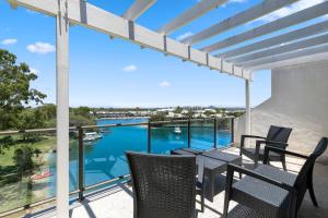 努沙岬的住宿－太陽湖度假酒店，阳台配有桌椅,享有水景。
