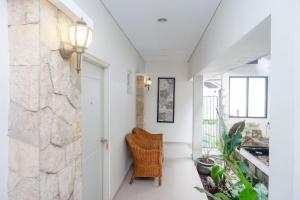 a hallway with a chair and a stone wall at RedDoorz near Jogja City Mall in Yogyakarta