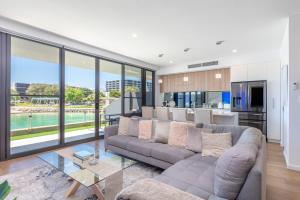 a living room with a large couch and a kitchen at Maraboo Island Beachfront Villa in Fremantle