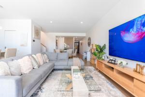 a living room with a couch and a large screen tv at Maraboo Island Beachfront Villa in Fremantle