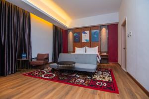 a bedroom with a bed and a red rug at Parkside Gayo Petro Hotel Takengon in Takengon