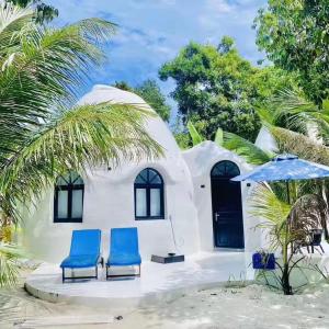 una casa en la playa con dos sillas azules y una sombrilla en Moonlight Resort, en Koh Rong Sanloem