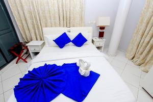um quarto com guarda-sóis azuis numa cama em Hotel Galilée em Cotonou