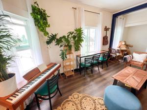 een woonkamer met een piano en een tafel en stoelen bij ITH Mission Beach Backpacker Hostel in San Diego