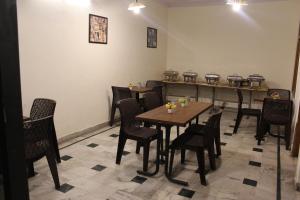 a dining room with a table and chairs and pans at Hotel Maharana Palace in Mathura