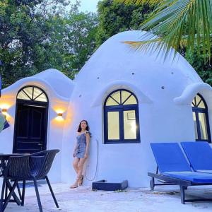 a woman standing in front of a round house at Moonlight Resort in Koh Rong Sanloem