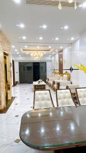 a large lobby with white chairs and a table at Perles Villa - Venue Travel in Ha Long