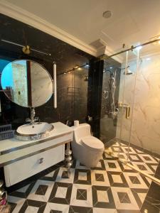 a bathroom with a toilet and a sink and a shower at Perles Villa - Venue Travel in Ha Long