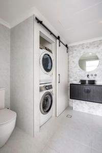 La salle de bains est pourvue d'un lave-linge et d'un sèche-linge. dans l'établissement Milson Serviced Apartments, à Sydney