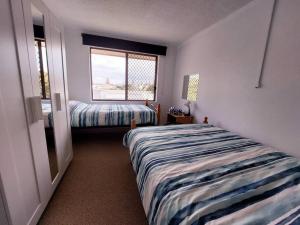 a bedroom with two beds and a window at Beachside spacious unit 9 in Tuncurry