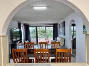 a dining room with a table and chairs and a living room at Beachside spacious unit 9 in Tuncurry
