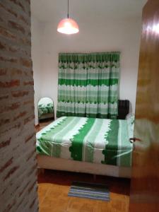 a bedroom with a green bed and a window at PUNTO FIJO in Zárate