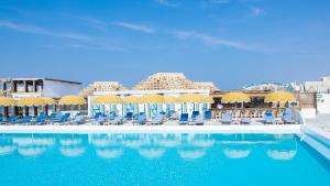 uma piscina com cadeiras azuis e guarda-sóis em Banan Beach em Ras al-Khaimah