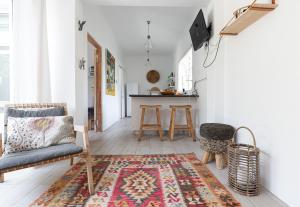 a living room with a chair and a rug at Shabby Chic in Muizenberg