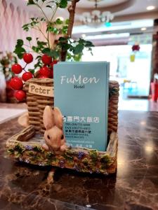 a stuffed rabbit sitting on a table next to a book at Fu Men Hotel in Pingtung City