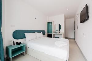 1 dormitorio con 1 cama blanca y TV en Moon Budget Hotel, en Ao Nang Beach
