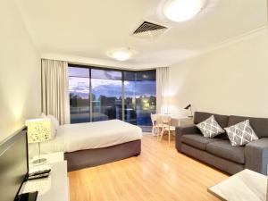 a hotel room with a bed and a couch and a table at Milson Serviced Apartments in Sydney