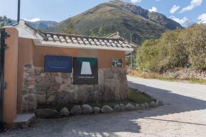 een bord aan de zijkant van een gebouw naast een weg bij Casa Andina Premium Valle Sagrado Hotel & Villas in Urubamba