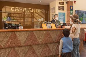 a woman and a child standing in front of a counter at Casa Andina Premium Valle Sagrado Hotel & Villas in Urubamba