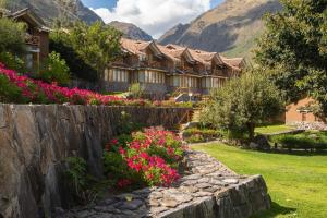 une maison ornée de fleurs et d'un mur en pierre dans l'établissement Casa Andina Premium Valle Sagrado Hotel & Villas, à Urubamba