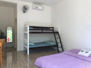 a bedroom with a bunk bed with purple sheets at Mộc Lam Homestay in Xóm Chum Găng