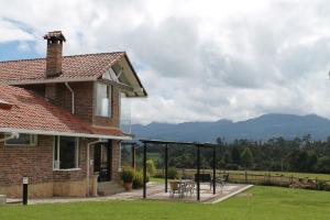 Cette maison dispose d'une terrasse avec une table et des chaises. dans l'établissement Villa La F, à Guasca