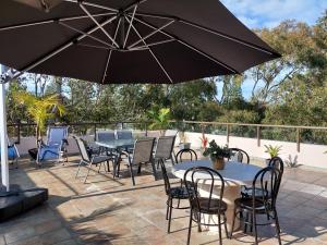 a patio with a table and chairs and an umbrella at Beachside spacious unit 9 in Tuncurry