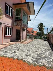 a house with a brick driveway in front of a building at HOMESTAY D' SEPANGAR HILLS in Kota Kinabalu