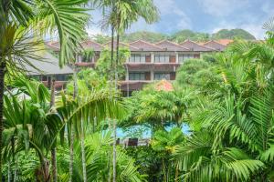 un complexe avec des palmiers en face d'un bâtiment dans l'établissement Palm Beach Hotel Bali, à Kuta