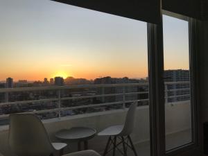 - une vue sur le coucher du soleil depuis le balcon d'un bâtiment dans l'établissement Elegante y acogedor departamento con gran vista, cercano a todo, à Concepción