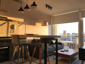 eine Küche mit einem Tisch und Stühlen im Zimmer in der Unterkunft Elegante y acogedor departamento con gran vista, cercano a todo in Concepción