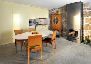 a kitchen with a table and chairs and a fireplace at Casas do Soito in Seia