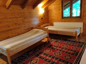 um quarto com duas camas num chalé de madeira em Kuća u šumi - Forest house near National park Una - Air Spa Lohovo em Bihać