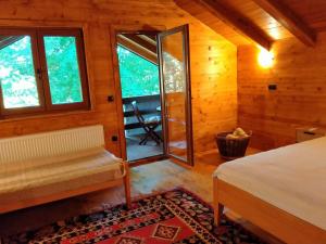 a bedroom with a bed and windows in a cabin at Kuća u šumi - Forest house near National park Una - Air Spa Lohovo in Bihać +28 photos