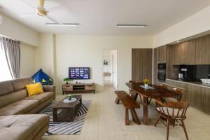 a living room with a couch and a table at By The Sea Beach Front Apartment in Batu Ferringhi