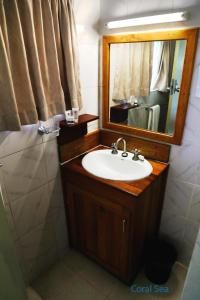 a bathroom with a sink and a mirror at Huon Gulf Hotel in Lae