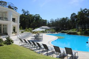 - une rangée de chaises à côté de la piscine dans l'établissement GREEN PARK - Apartamento Torre J - Punta del Este - Resort & Spa, à Punta del Este