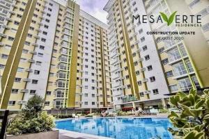 a view of some apartment buildings with a swimming pool at Cozy Mesaverte Condo Residences in Cagayan de Oro