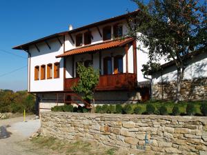 a white house with a stone wall in front of it at Panorama Hotel in Arbanasi