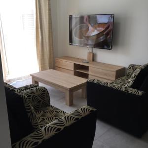 a living room with a tv and a coffee table at BR COURT-PARKVIEW SODNAC in Quatre Bornes