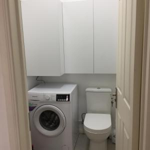 a small bathroom with a washing machine and a toilet at BR COURT-PARKVIEW SODNAC in Quatre Bornes