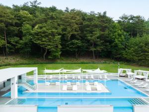 a swimming pool with white chairs and a swimming poolvisor at The Suites Hotel Namwon in Namwon