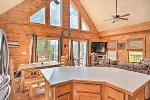 a log cabin kitchen and living room with a ceiling fan at Grand Windham Retreat with Fire Pit and Game Room in Windham
