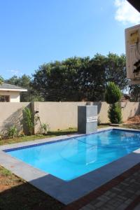 une grande piscine bleue en face d'une maison dans l'établissement Royal relax guest house, à Palatswe
